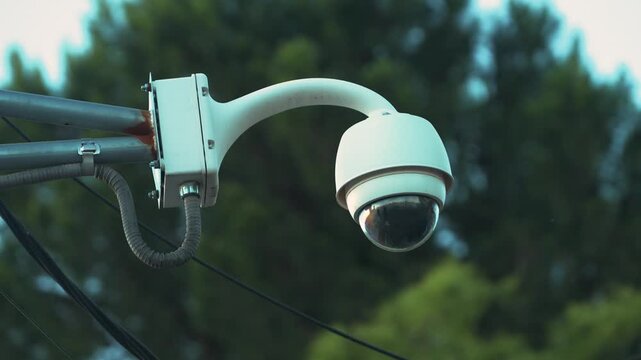 Close up of outdoor surveillance dome camera on metal arm