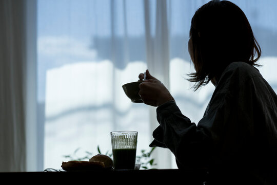 朝食を食べる40代日本人女性のシルエット