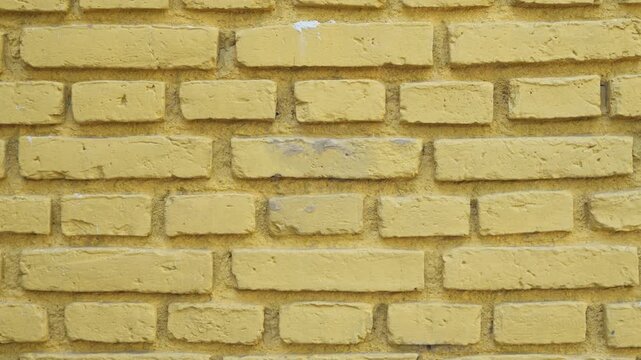 Yellow painted brick wall texture with masonry pattern