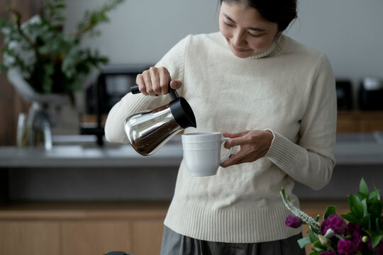 コーヒーをカップに注ぐ40代日本人女性