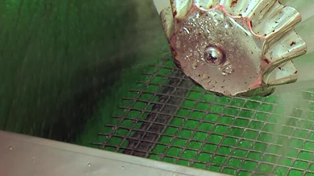 Observe a vital machine part, a gleaming metallic impeller, as it rotates within an industrial setting.