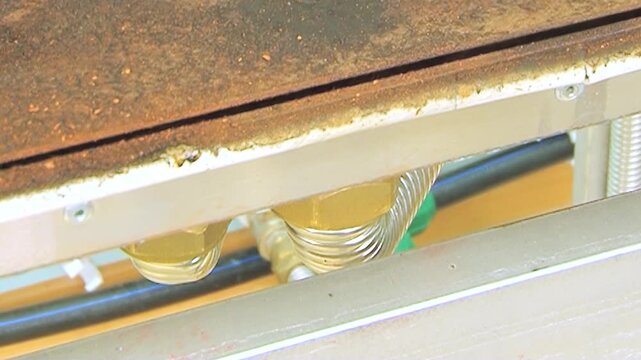 Intricate clear tubes filled with a golden fluid coil within a hardworking air filtration machine.
