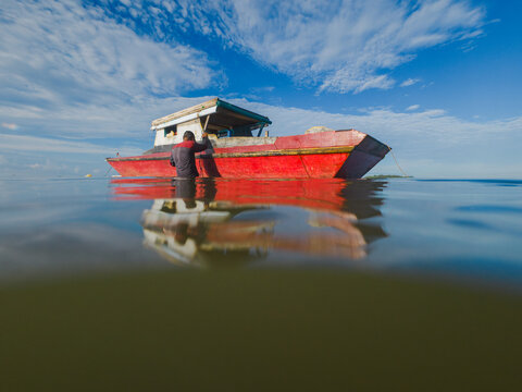 Traditional Fisherman with Red Boat on Calm Tropical Water