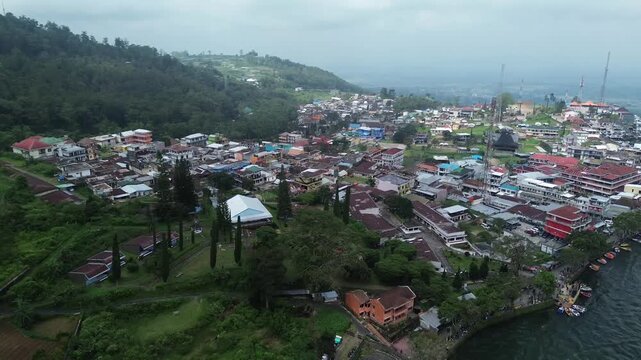 Pemandangan Udara Perkampungan Padat Penduduk di Lereng Bukit dan Tepi Perairan yang Asri