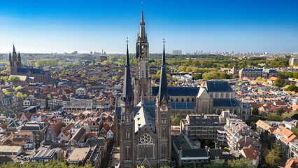 Naklejka premium Aerial drone view of Delft with historic cathedrals, panoramic cityscape of old town Delft with traditional Dutch architecture, market square and city center, the Netherlands