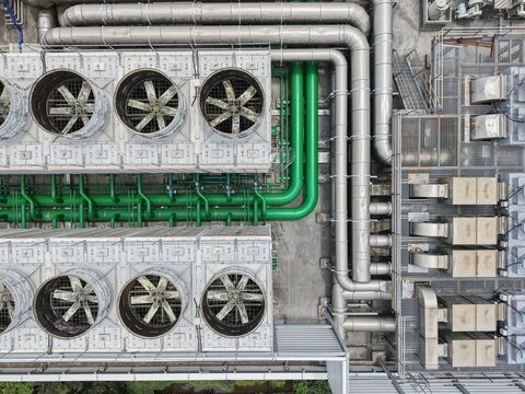 Top down view of industrial cooling towers and pipes.