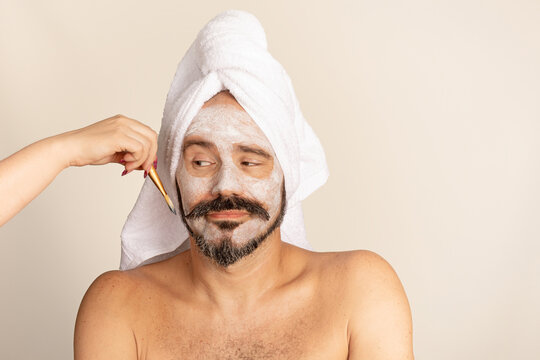Male skincare routine with face mask and towel wrap