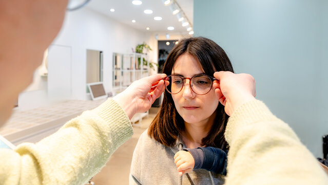 Customer trying on glasses at optical center