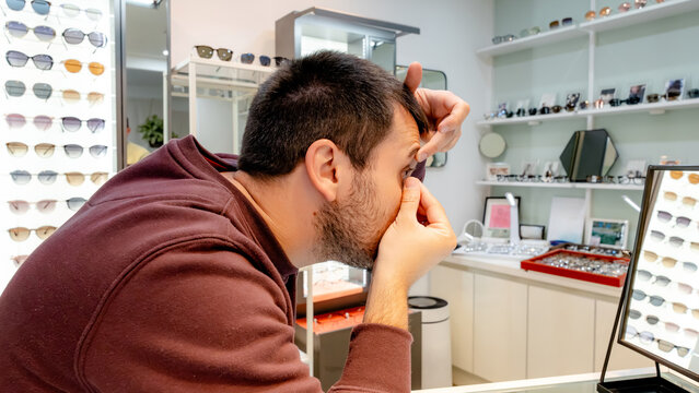 Man trying on contact lenses at optical store