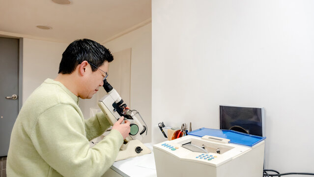 Optical lab technician examining glasses with precision