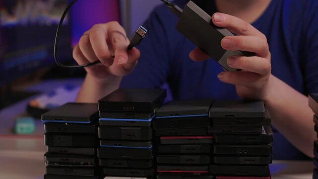 Precise sorting of multiple external storage devices in orderly rows. Systematic placement of various external hard discs emphasizing organization and cataloging principles