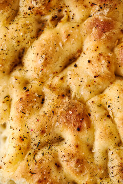Close-up of golden focaccia flatbread with herbs and salt