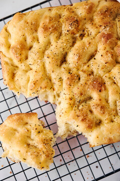 Freshly baked focaccia flatbread with herbs on rack