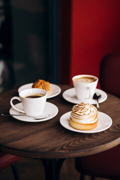 Cozy cafe table with coffee cups and sweet pastry