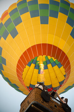 Colorful hot air balloon flight with burner flame and basket