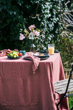 Outdoor breakfast table with granola, fruit and juice