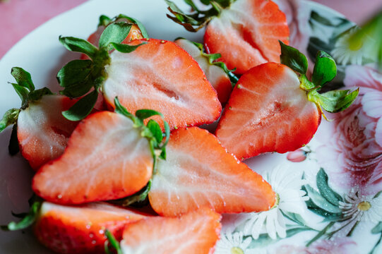 Fresh sliced strawberry on floral plate for spring snack
