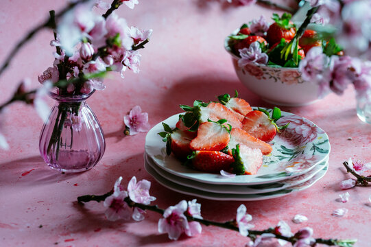 Spring strawberry still life with blossom and floral tableware