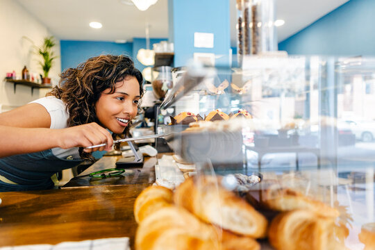 Employee serving fresh baked goods in a cafe
