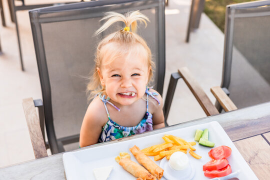 Girl enjoying breakfast on terrace with healthy food plate