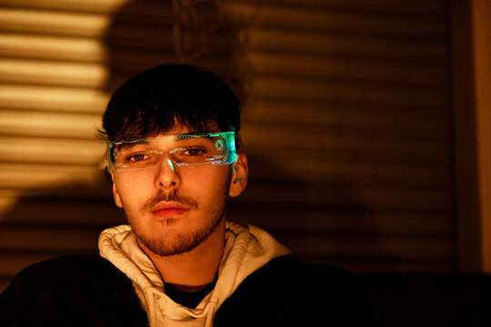 Man in cyber glasses at night with glowing digital overlay