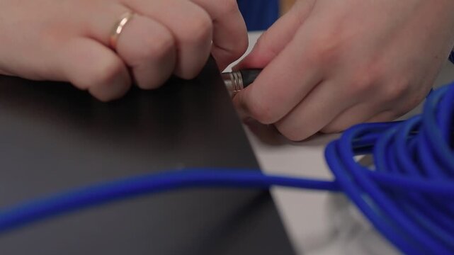 Sound technician connecting equipment. Detailed view of sound engineer attaching connector to device. Precise handling of audio cables during studio equipment setup and testing