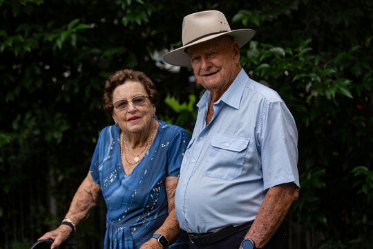 smiling portrait of elderly woman and old man standing together outside on overcast day
