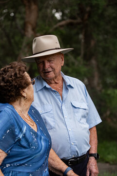 Elderly woman standing close and talking to elderly man