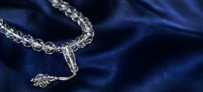 Crystal Islamic Prayer Beads Misbaha on Elegant Blue Silk Fabric Background