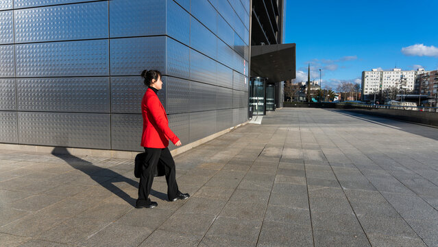 Middle-aged professional woman walking by office building