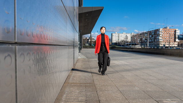 Businesswoman walking with briefcase outside