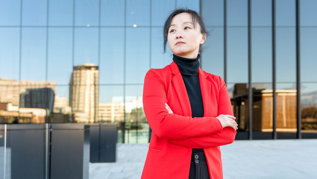 Confident businesswoman in a red blazer outside office