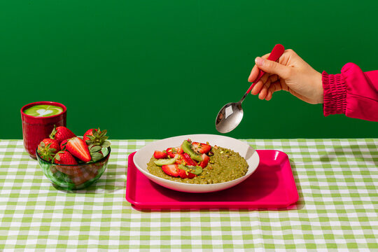Matcha porridge with strawberry and kiwi on vichy table