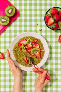 Matcha porridge with strawberry and kiwi on vichy cloth
