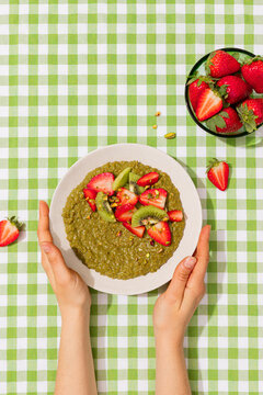 Matcha porridge with strawberry and kiwi on vichy cloth