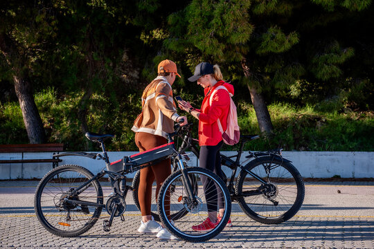 Friends checking route before electric bicycle ride in park