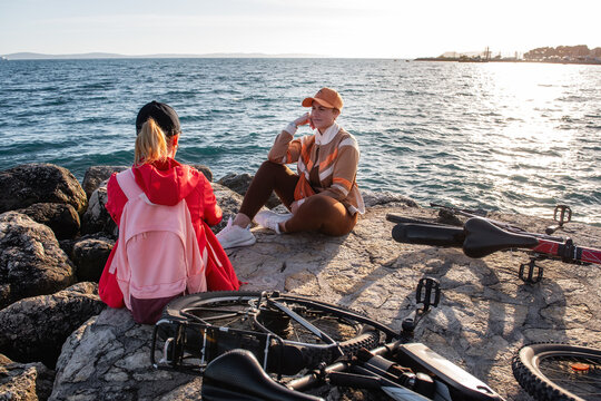 Friends resting by sea during electric bicycle sport ride