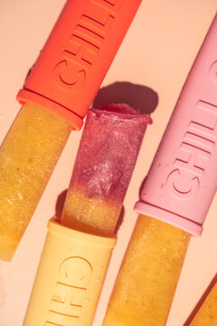 Homemade fruit ice popsicles in colorful molds for summer