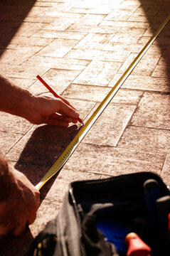 Technician measuring tile floor for safe maintenance repair
