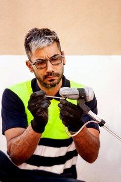 Technician repairing satellite LNB with screwdriver outdoors