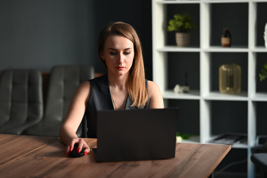 Focused businesswoman working on laptop at office desk