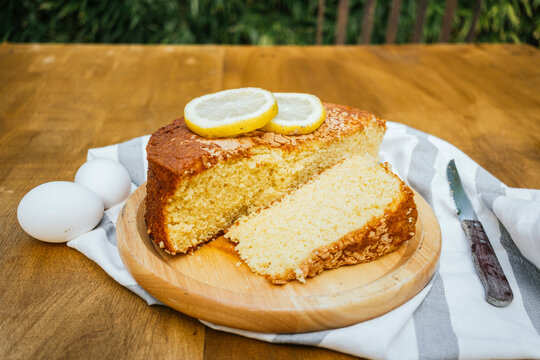 Homemade lemon sponge cake slice on wooden board
