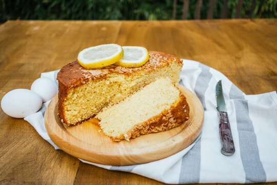 Homemade lemon sponge cake slice on wooden board