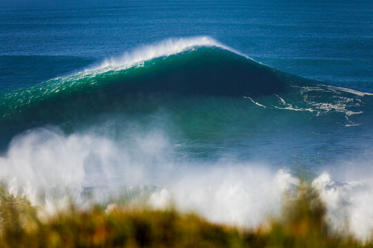 Powerful ocean wave breaking with spray and turquoise water