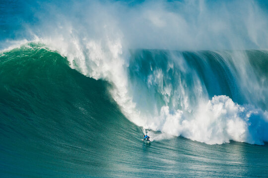 Surfer riding a massive Atlantic wave in Portugal