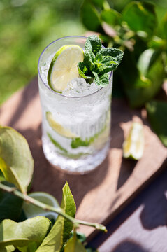 Top view of fresh mojito cocktail with lime and mint on wooden board
