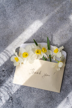 Daffodils in an envelope with a thank you note