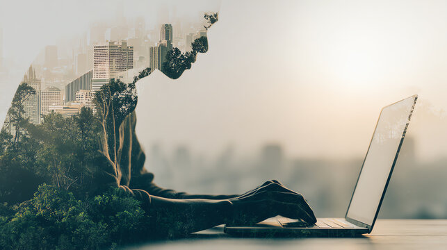 A double exposure image of a person working on a laptop, blending urban and natural landscapes.