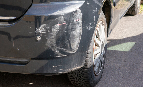 Car bumper with scratches and dents after a parking accident while driving out