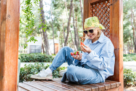 Woman enjoying fruit outdoors in casual setting